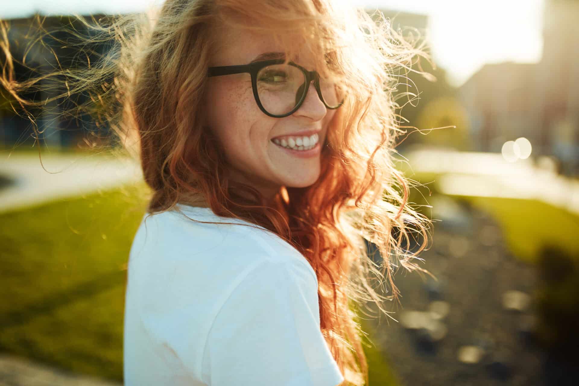 Young woman with glasses, smiling in the city